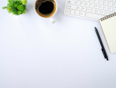 Top view above of White office desk table with keyboard, notebook and coffee cup with equipment other office supplies. Business and finance concept. Workplace, Flat lay with blank copy space.の写真素材