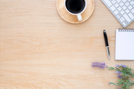 Workplace in office with wooden desk. Top view above of keyboard computer with notebook and pen. Space for modern creative work of designer. Flat lay with copy space. Business-finance concept.の写真素材