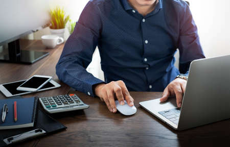 image of Businessman using mouse computer and typing keyboard of laptop computer notebook on office desk. Workspace, working project for job online network. Business finance and technology concept.の写真素材
