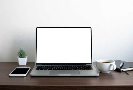 Wooden office desk table with keyboard of laptop computer with empty screen and phone. Business and finance concept. Workplace, Flat lay with blank copy space.の写真素材