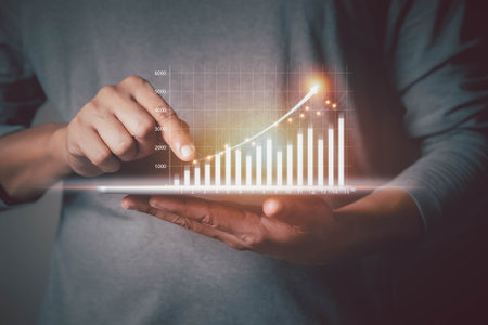 Analysis invest strategy data online connection technology. Businessman holding tablet showing graph growth stock hologram chart and diagram, forex chart. Business finance and Market trading concept.の写真素材