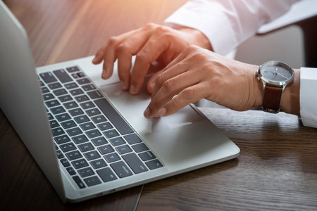 Close-up of man hand using and typing keyboard of laptop computer on office desk. Workspace, businessman working project creative idea for job online network. Business finance and technology concept.の写真素材