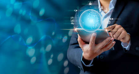 Businessman holding tablet showing virtual globe diagram. Social digital, Analysis strategy sale marketing and economic data online network connection. Business finance and digital technology concept.の写真素材