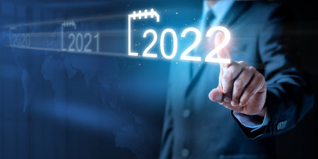 Businessman pointing touch to future of calendar new year 2022. Plans to increase business growth and Analysis strategy market plan for target future. Plan business growth in year 2022 concept.の写真素材