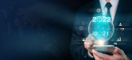 Businessman using mobile smartphone with business financial icons. Plans to increase business growth and Analysis strategy market plan for target future. Digital technology year 2022 concept.の写真素材