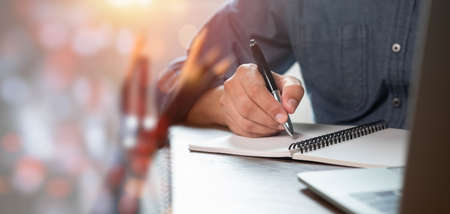 Close-up of man hand using writing pen memo on notebook paper or letter, diary on table desk office....