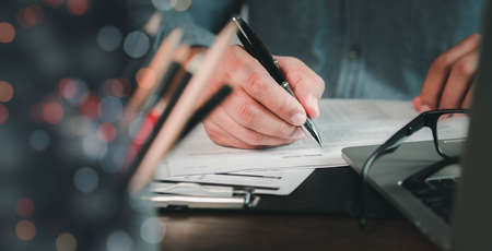 Close-up of man hand using writing pen memo on notebook paper or letter, diary on table desk office....