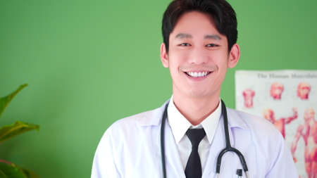 Portrait of Confident Asian young male physician smile, posing in hospital medical office. Expertise, professional doctor therapist in uniform white lab coat and stethoscope.の写真素材
