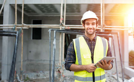 Professional male civil engineer or architect wear safety helmet. Engineer, inspector holding tablet...