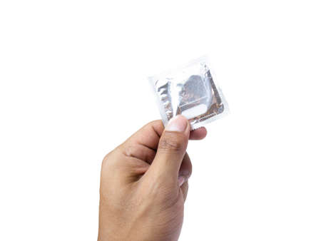 Tan skin Hand holding a condom package isolated on a white background.の写真素材