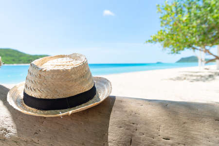 Straw hat on the timber with beach and seaside fresh sky background. Holiday and Vacation concept. Chilling and Relax concept. Fresh Holiday. Summertime.の写真素材