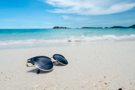 Black Sunglasses on the Sea background. beautiful sand beach as summertime, Travel and vacation concept. Holiday concept. chilling on the sea. Copy space for message.の写真素材
