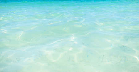 Blue and bright and clear water surface and ripple wave with sun reflection in the sea. close up sea wave, low angle view.の写真素材