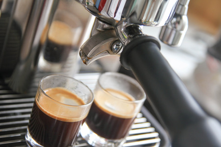 Close-up of espresso machine pouring coffee in a Glassの写真素材