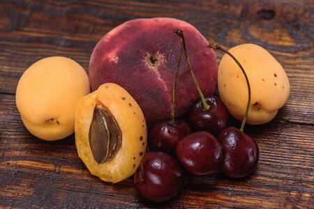 Fruits fig peaches, half of apricot and cherry on dark wooden tableの写真素材