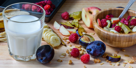 Bowl of muesli with berries, fruits and milk - good and healthy breakfast. Scattered ingredients and slices of fruitsの写真素材