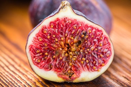 Ripe sliced figs on a wooden surface.の写真素材
