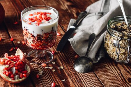 Prepared Dessert with Ingredients on Wooden Table. Series on Prepare Healthy Dessert with Pomegranate, Granola, Cream and Jamの写真素材