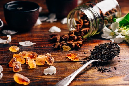 Spoonful of Tea, Apple Flowers, Sugar and Scattered Anise Star on Wooden Table.の写真素材