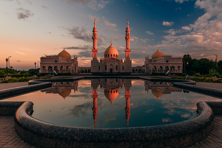 Beautiful White Mosque with Domes and Minarets at Sunset Light. Reflection on Water Surface. Bolghar, Rusiia.の写真素材