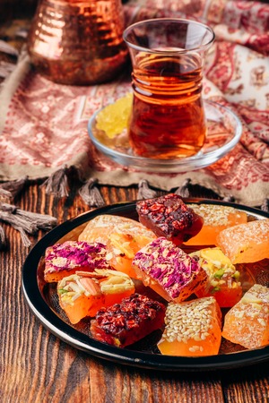 Oriental delight rahat lokum with tea in armudu over tablecloth with ornamentの写真素材
