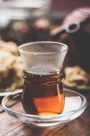 Armudu glass with black tea with kitchenware on backgroundの写真素材