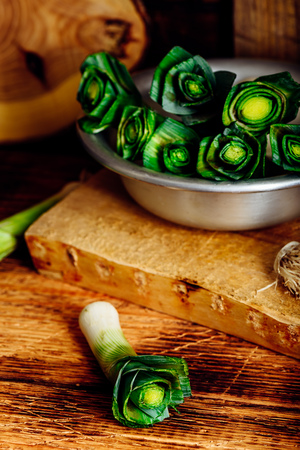 Fresh leek in a metal bowl on rustic kitchenの写真素材