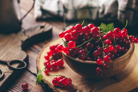Fresh picked red currants in wooden bowlの写真素材