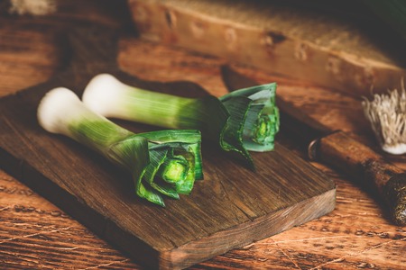 Fresh green leek on wooden cutting boardの写真素材