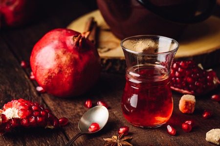 Fruit tea in armudu glass with fresh pomegranate and some spicesの写真素材