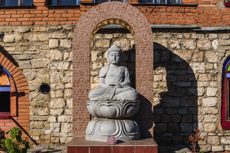 White stone statue of a Buddha on masonry backgroundの写真素材