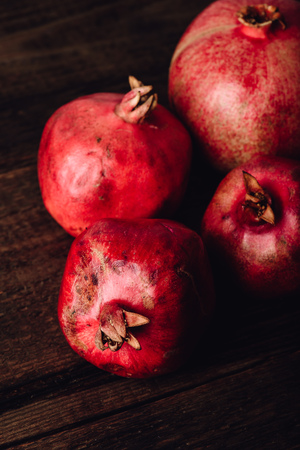 Four ripe pomegranate on rustic wooden tableの写真素材