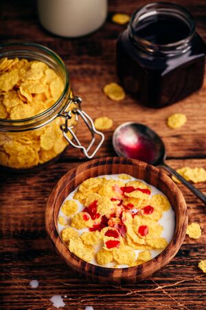 Breakfast with corn flakes, milk and berry syrupの写真素材