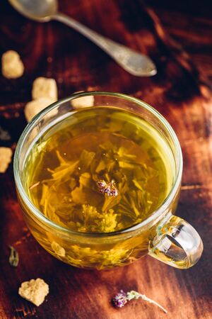 Cup of green tea with brown tea sugar on a wooden backgroundの写真素材