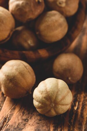 Sun dried limes in rustic wooden bowlの写真素材