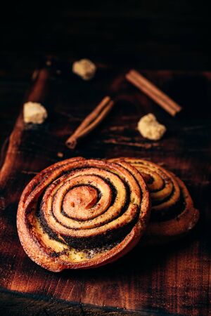 Sweet roll with poppy seeds on rustic wooden surfaceの写真素材