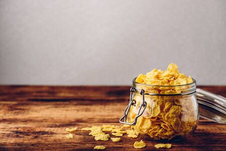 Corn flakes in a glass jar on wooden surfaceの写真素材