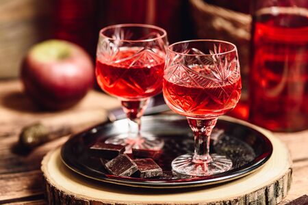 Glass of red liquor with chocolate bars on metal trayの写真素材
