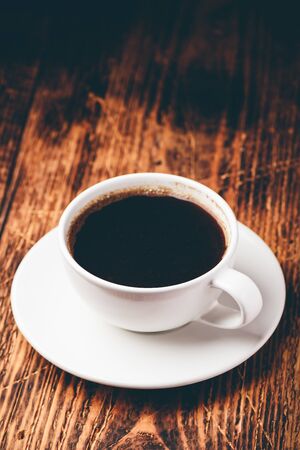 Black coffee in white cup over wooden surfaceの写真素材