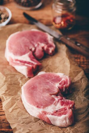 Two pork loin steaks on baking paperの写真素材
