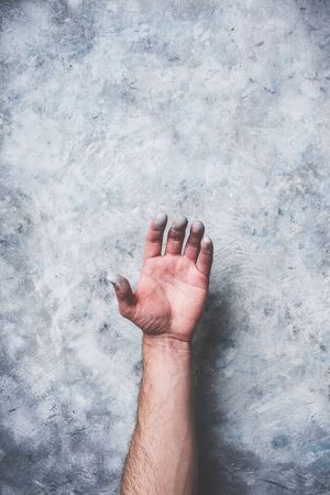 Man hand covered with paint on gray concrete wallの写真素材