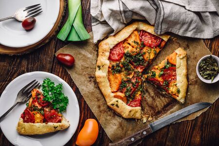Freshly baked and sliced tomato galette on baking paper. View from aboveの写真素材