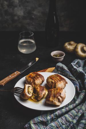 Bacon-wrapped button mushrooms stuffed with grated cheddar cheese and spicesの写真素材
