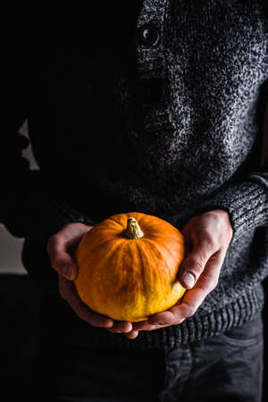 Man holding small ripe pumpkin in handsの写真素材