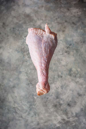 Raw turkey leg on light concrete backgroundの写真素材