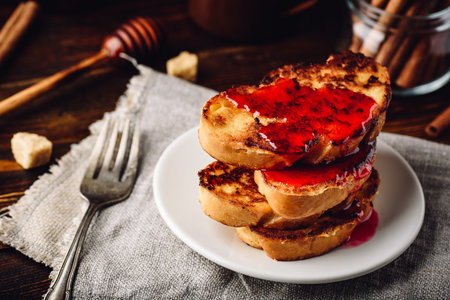 Stack of french toasts with berry marmalade on white plateの写真素材