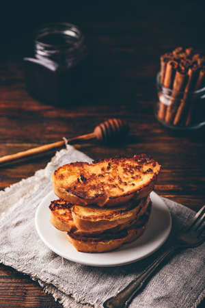 French toasts on white plate over wooden surface