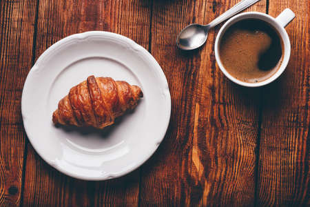 Cup of Coffee And Croissant on Rustic Table. View from Aboveの写真素材
