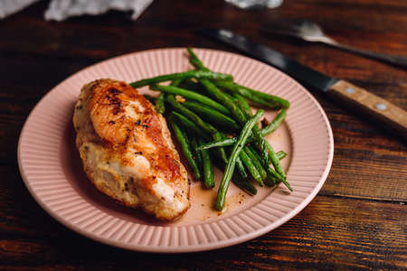Chicken Breast Baked in Oven and Green Beans Fried with Garlic and Thyme on Plateの写真素材
