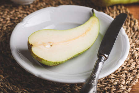 Half of Conference Pear on White Plate with Knifeの写真素材